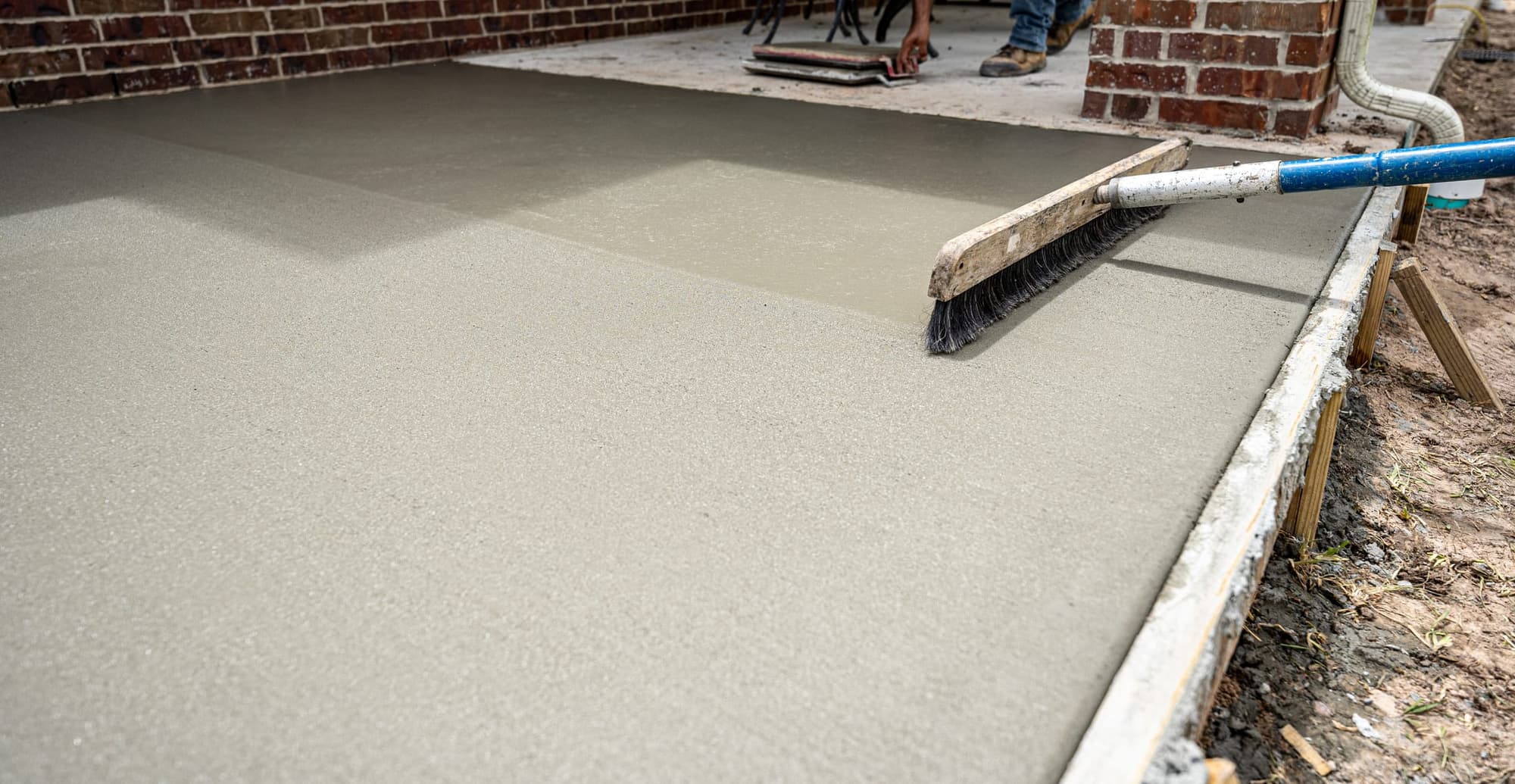 Broom pulled across a freshly screeded patio slab to give it texture