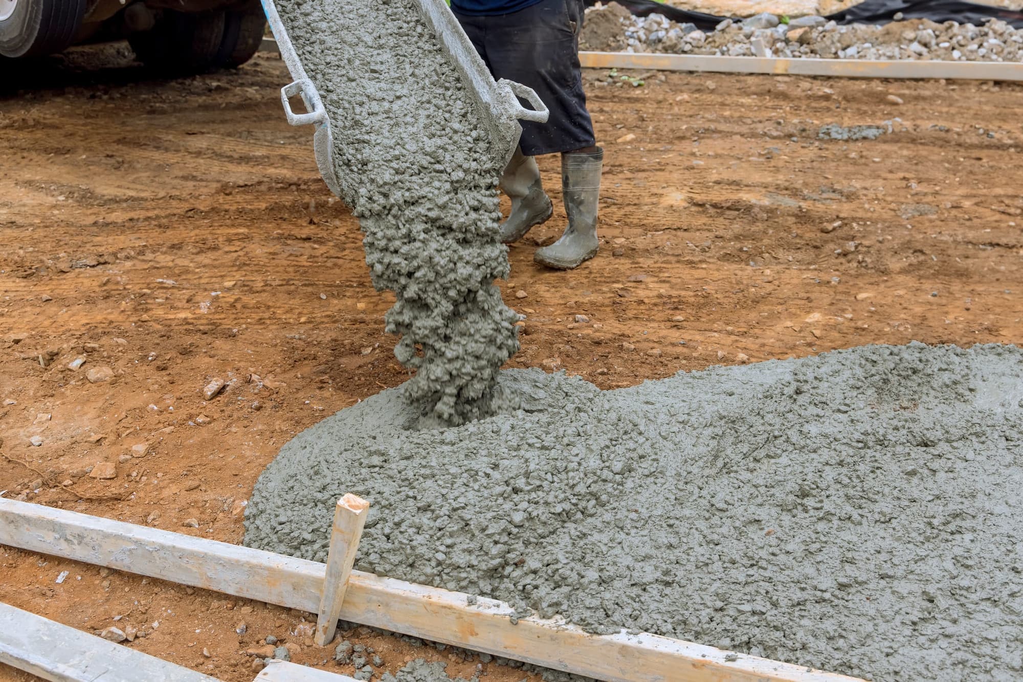 Concrete pouring onto a prepared base inside wood forms