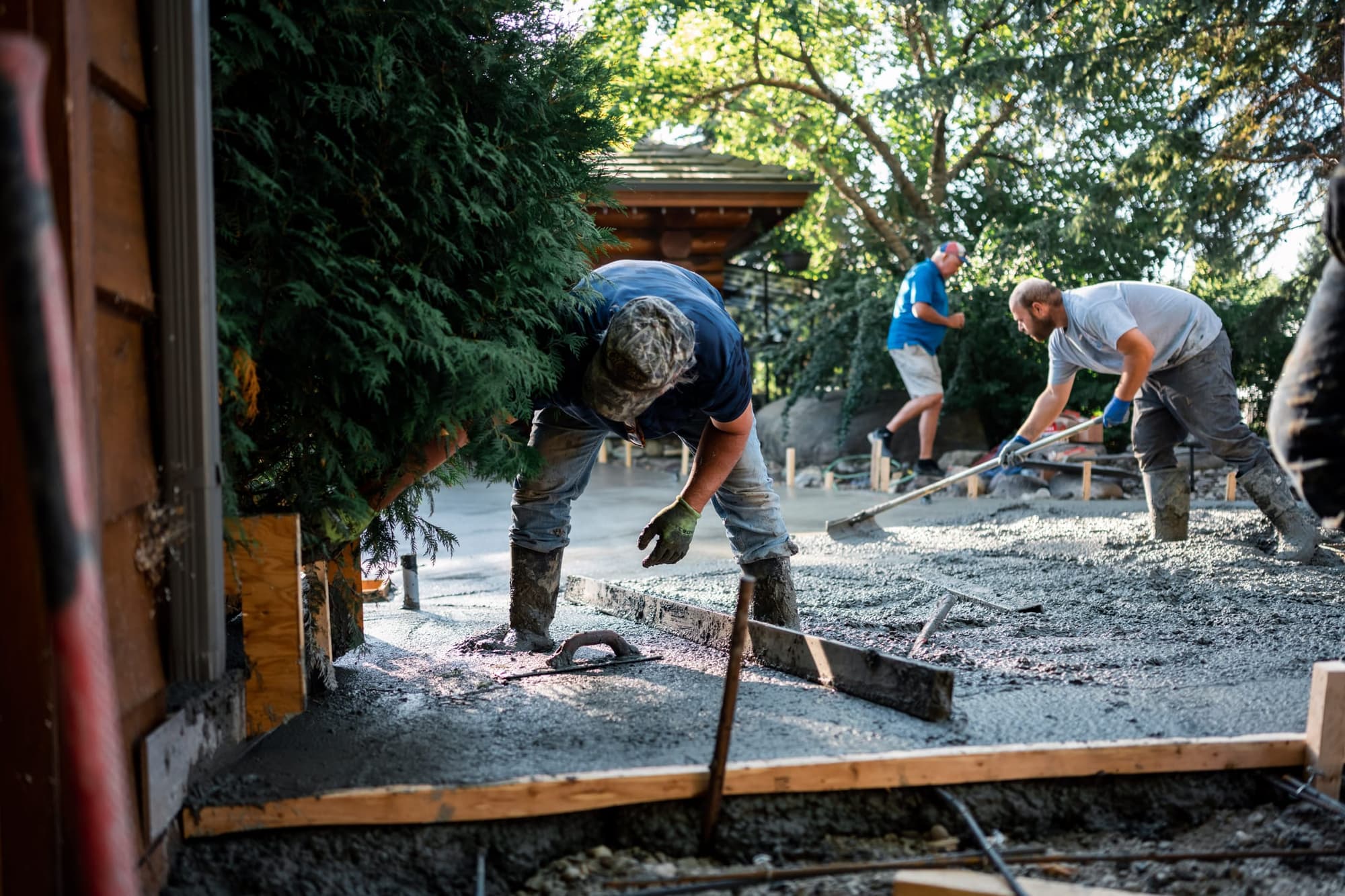 Crew screeding a residential slab inside wood forms