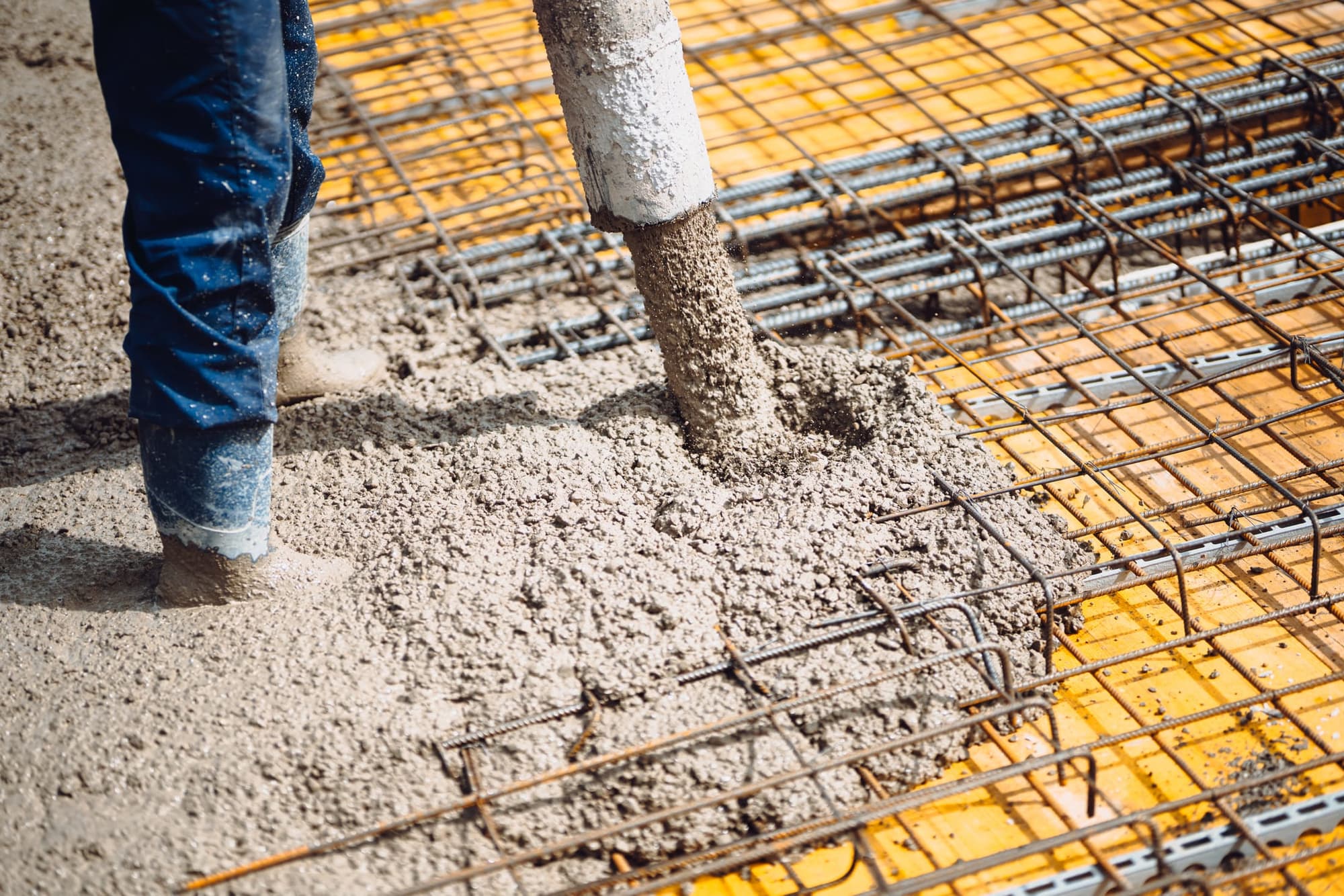 Pump hose placing concrete over a rebar grid