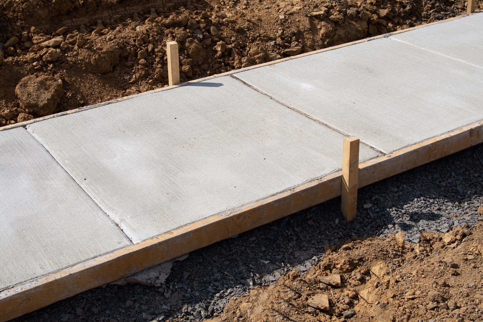 Finished sidewalk sections with control joints still in their forms